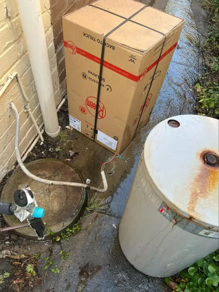 Old hot water unit beside the boxed replacement unit